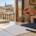 Mano sosteniendo unas llaves sobre una mesa con documentos en una vivienda con vistas a Toledo.